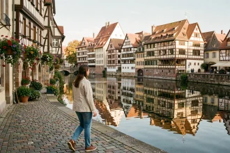 Femme se promenant le long des quais de la Petite France à Strasbourg par une journée ensoleillée d'automne