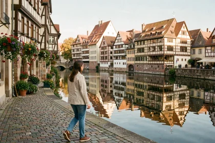 Femme se promenant le long des quais de la Petite France à Strasbourg par une journée ensoleillée d'automne